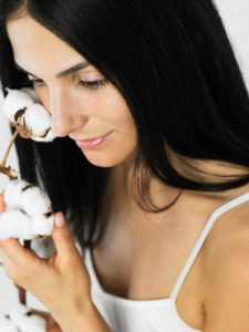 Woman Touching Cotton Plant to Face --- Image by © Whitemann/Corbis